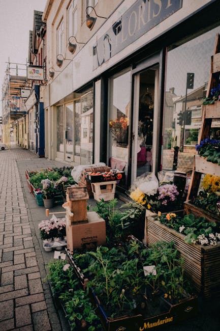 An outdoor display of floral arrangements and potted plants outside a florist shop on Wanstead High Street. The arrangement includes a variety of fresh flowers in different colours such as pink, white